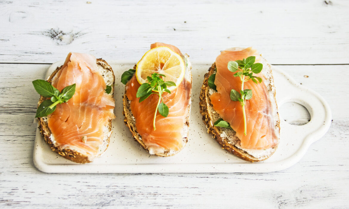 Sandwiches with Salmon and Lemon on a Tree Background